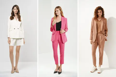 Trzy kobiety w eleganckich stylizacjach. Jedna w białym garniturze ze spodenkami, druga w różowym z długimi spodniami, trzecia w beżowym. Co pod marynarkę damską? Różne opcje.