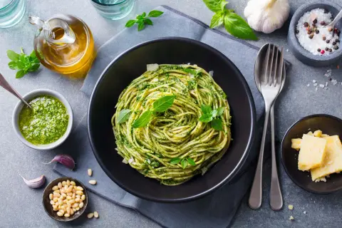 Szybkie dania bezmięsne na obiad: spaghetti z pesto, świeżą bazylią, orzeszkami pinii i parmezanem.