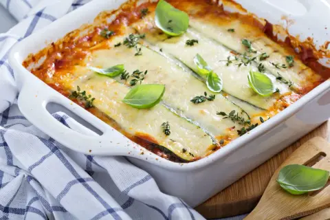 Lasagne courgette gratinée, dorée et savoureuse, garnie de feuilles de basilic frais et de thym. Un délice léger et réconfortant.