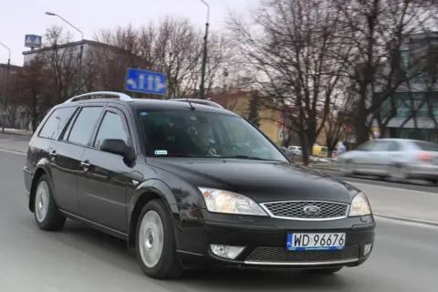 Czarny Ford Mondeo MK2 kombi jedzie ulicą.