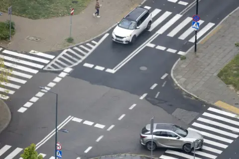 Na skrzyżowaniu równorzędnym biały SUV i srebrny crossover czekają na zielone światło.