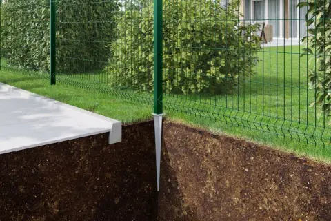 Montaż słupków ogrodzeniowych instrukcja: zielony słupek z metalową stopą wbity w ziemię, obok betonowy chodnik i siatka ogrodzeniowa.