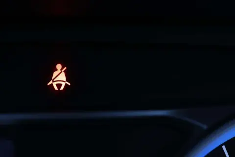Testigo de cinturón de seguridad encendido en el tablero de un coche. Indica que no está abrochado.