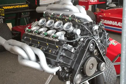 Motor V8 de F1 con colectores de escape plateados y trompetas de admisión. Un motor potente listo para la carrera.