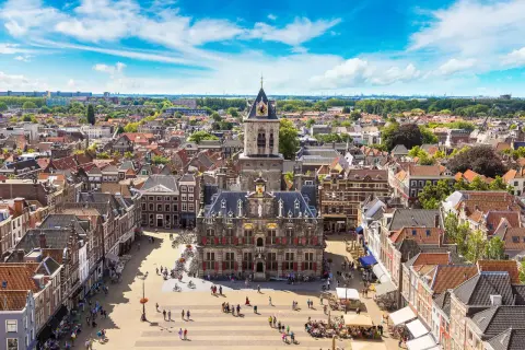 Luftaufnahme von Delft mit dem Rathaus im Zentrum. Entdecken Sie die charmanten Gassen und versteckten Plätze – echte Delft Geheimtipps.