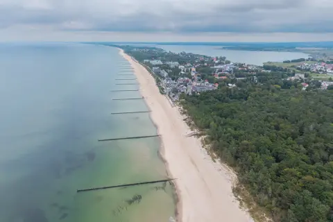 Mielno atrakcje: szeroka plaża, morze, las i zabudowania kurortu rozciągają się wzdłuż wybrzeża.