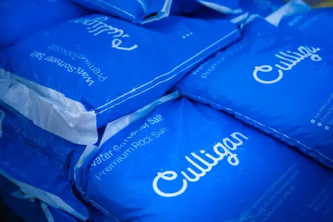 Pile de sacs bleus Culligan de sel pour adoucisseur d'eau. Difficile de dire combien de sac de sel pour adoucisseur il y a au total.