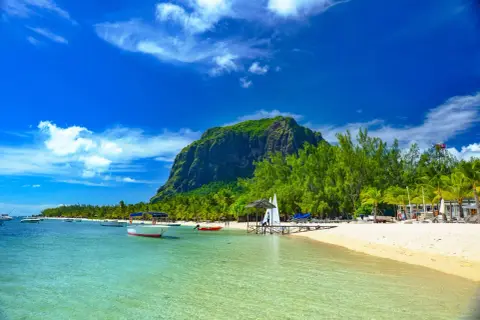Rajska plaża na Mauritiusie z łodziami i górą Le Morne. Uważaj na silne słońce i prądy morskie.