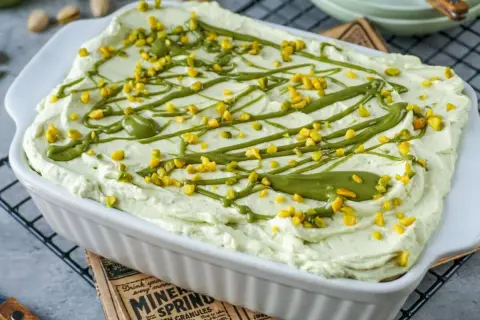 Cremiges Pistazien Tiramisu, verziert mit gehackten Pistazien und einer grünen Glasur, bereit zum Genießen.