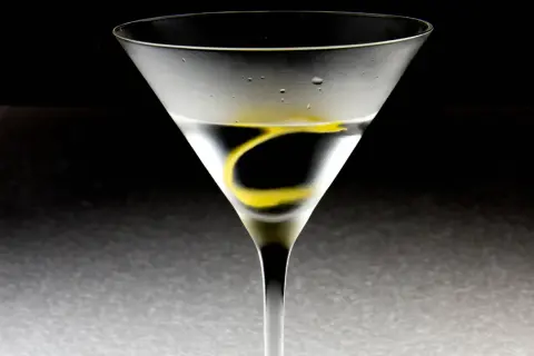 Ein Martini-Cocktail in einem Glas mit Zitronenzeste und Kondenswasser.