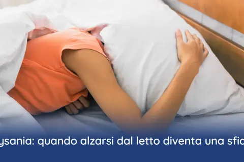 Persona rannicchiata sotto le coperte, con la testa affondata nel cuscino. La sensazione di non riuscire a svegliarsi la mattina, un sintomo di depressione.