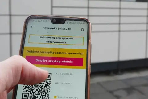 Dłoń trzyma telefon z widocznym kodem QR InPost. Aplikacja pokazuje opcję otwarcia skrytki zdalnie.