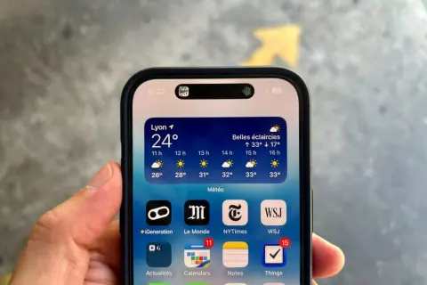 iPhone avec la Dynamic Island affichant la météo à Lyon. La barre d'état montre l'heure et le niveau de batterie.