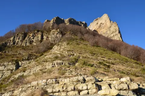 Vue spectaculaire des 3 becs, falaises rocheuses et arbres dénudés sous un ciel bleu intense.