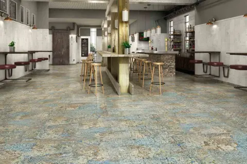 Sol usé et texturé, évoquant le recyclage carrelage, dans un bar industriel avec des tabourets en bois et des banquettes en cuir.