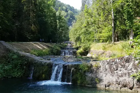 La cascade du Morel dévale une série de bassins aménagés, entourée d'une végétation luxuriante et de promeneurs.