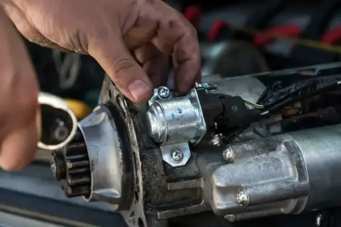 Mechanik sprawdza rozrusznik na krótko, przykręcając solenoid.