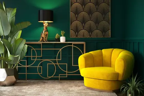 Elegancja w stylu sztuka art deco: złoty kot-lampa, żółty fotel i geometryczne zdobienia na tle butelkowej zieleni.