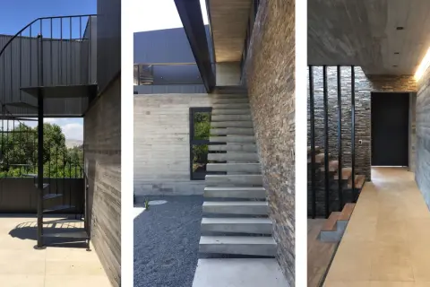 Scale esterne bellissime in metallo nero e cemento, con un design moderno che si integra perfettamente con la pietra naturale e il legno.