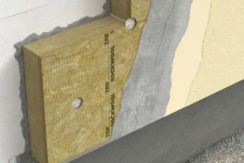Warstwa izolacyjna z wełny skalnej 10, zaprawa, siatka i tynk na ścianie zewnętrznej.