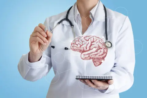 Un médecin en blouse blanche, stéthoscope autour du cou, pointe un cerveau schématisé. Il soigne ce que soigne un neurologue.