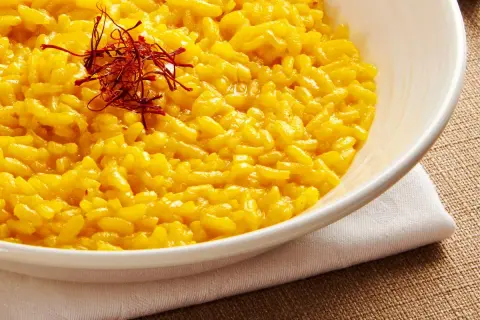 Aksamitne risotto alla milanese, złociste i aromatyczne, ozdobione nitkami szafranu.
