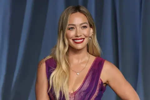 Hilary Duff, bekannt für ihre Filme und Serien, strahlt in einem lila Kleid.