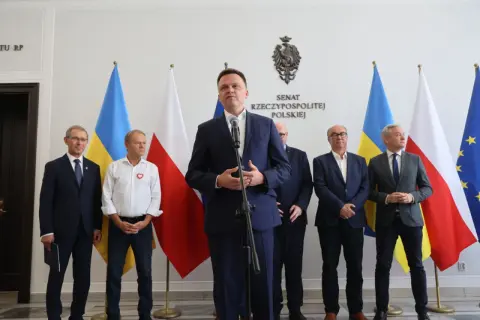 Pakt senacki: jak lewica negocjowała miejsca na listach wyborczych. Politycy stoją przed flagami Polski i Ukrainy.
