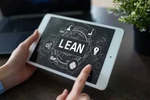 Tablet z ekranem prezentującym koncepcję lean management. Ikony symbolizują procesy, innowacje i optymalizację.