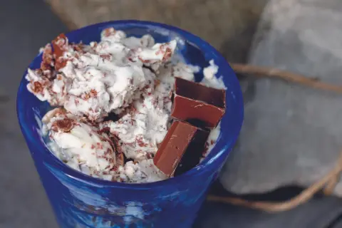 Blå skål med krämig glass och chokladbitar. Ett enkelt glass recept för en varm sommardag.