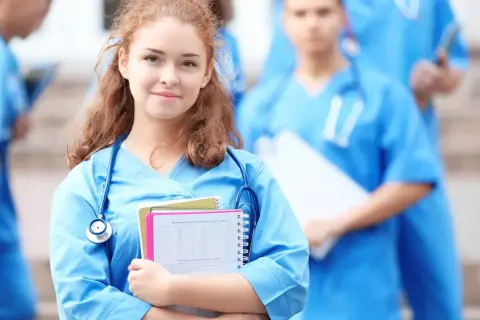 Młoda lekarka w niebieskim uniformie ze stetoskopem i notatkami.