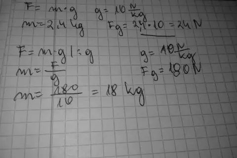 Ręcznie pisane wzory fizyczne na kratkowanym papierze, w tym F=m*g i obliczenia.