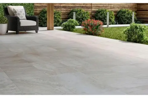 Terraza moderna con mobiliario de exterior y césped. El suelo de baldosas claras es el mejor suelo para exterior, duradero y elegante.