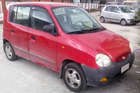 Röd Hyundai Atos parkerad utomhus. En annan silverfärgad bil syns i bakgrunden.