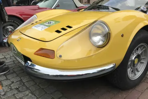Żółte Ferrari Dino z numerem 56 na naklejce, błyszczące chromem, gotowe do rajdu.