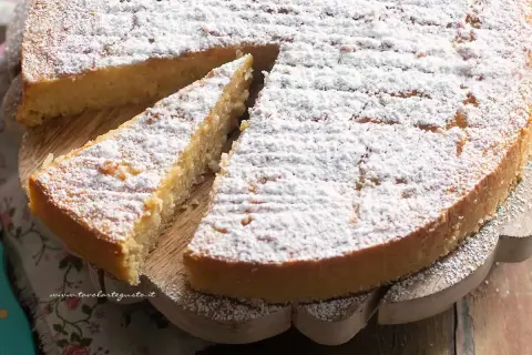 Una deliziosa torta di riso, soffice e spolverata di zucchero a velo, pronta per essere gustata.