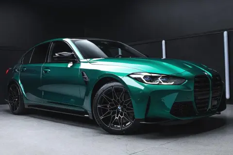 Błyszczący, sportowy sedan w kolorze midnight green, z czarnymi felgami i agresywnym przodem, gotowy na nocne wyścigi.