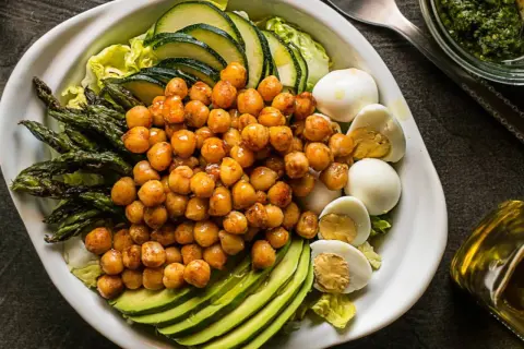 Ensalada de garbanzos con espárragos, aguacate, huevo duro y calabacín. Ingredientes frescos y saludables.
