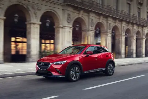 Czerwona Mazda CX-3 w ruchu miejskim. Wiele osób szuka mazda cx-3 opinie, by poznać ten stylowy crossover.