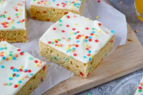 Bunte Streusel zieren das weiße Zuckerguss-Topping dieses leckeren Papageienkuchen Rezepts. Perfekt für jede Feier!