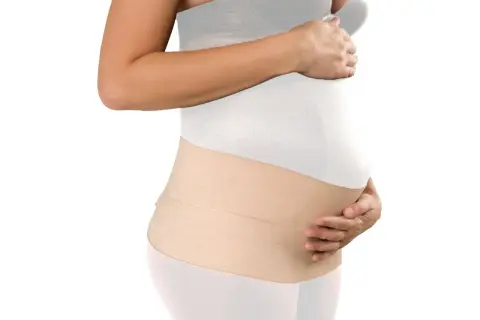 Mujer embarazada con una faja postparto de color beige, que brinda soporte y comodidad.