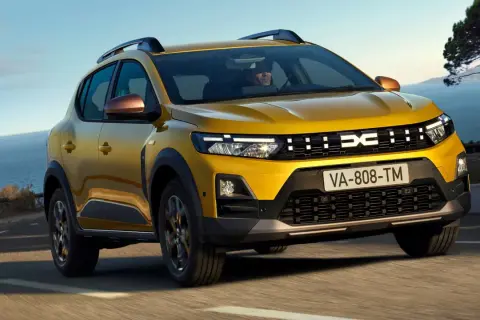 Żółty Dacia Sandero na drodze nad morzem. Sprawdź atrakcyjną dacia sandero cena!