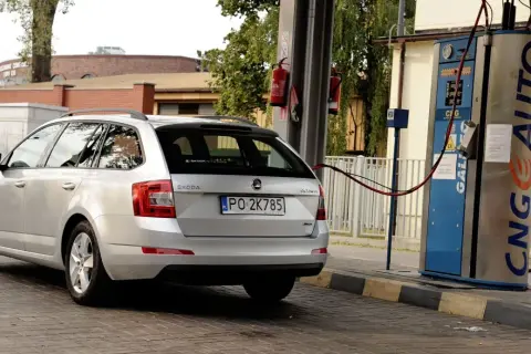Srebrne kombi Skoda Octavia tankuje gaz LPG propan-butan na stacji paliw.