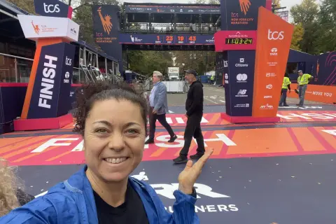 La finisher sorride alla telecamera vicino al traguardo della maratona New York.