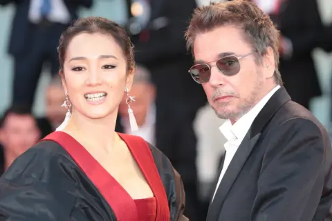 Jean-Michel Jarre z żoną, Gong Li, na czerwonym dywanie.