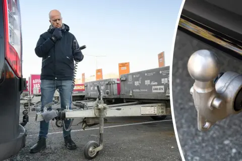 Man kontrollerar kopplingen till en släpvagn, kanske för att säkerställa att fordons totalvikt inte överskrids.