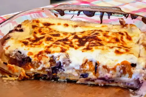 Lasagne con zucca e scamorza, dorate e filanti, in una teglia di vetro. Un piatto autunnale irresistibile.