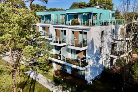 Nowoczesne władysławowo apartamenty przy plaży z widokiem na morze. Balkony z przeszklonymi balustradami i zielone otoczenie.