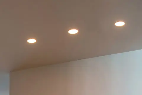 Trois spots encastrés éclairent un plafond. La lampe LED offre des avantages, mais il faut aussi considérer ses inconvénients.