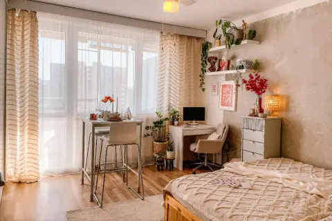 Idee per arredare una casa piccola: un angolo studio, un tavolo alto per mangiare e un letto accogliente, tutto in uno spazio compatto.